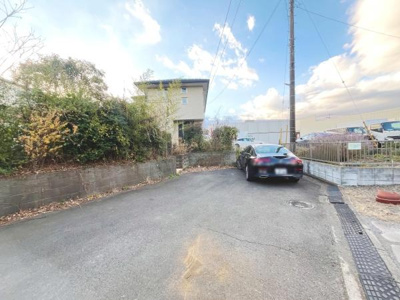 前面道路はフラットで歩きやすい印象です。道路幅も十分にあり車の出し入れもスムーズに行えます。周囲に緑があり落ち着いた雰囲気です。現地の様子がよく分かる一枚です。