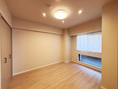 明るい天井照明が空間をやさしく照らします。大きな窓から自然光が入る洋室です。ナチュラルなフローリングが魅力的な印象を与えます。収納スペースも充実していて便利です。