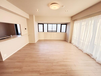 大きな窓から光がたっぷり差し込むリビングです。明るいフローリングが空間を広く感じさせます。カウンターキッチンが隣接し使い勝手の良いレイアウトです。開放感のある造りで快適に過ごせます。