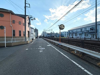 道路と線路が隣接した開放感のあるエリアです。周囲には住居や建物が整然と並んでいます。空が広く陽当たりを感じられる雰囲気です。ゆとりのある歩道も特徴です。