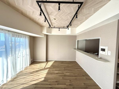 窓からの自然光がたっぷりと入るリビングです。開放感のある空間設計が魅力的です。シンプルな内装でさまざまなインテリアとも合わせやすいです。天井のデザインや照明もアクセントになっています。