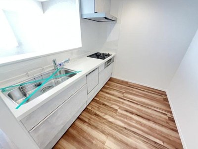 シンプルなデザインのキッチンです。明るい空間で日差しが入りやすく清潔感があります。収納スペースもしっかり確保されています。シンクやコンロまわりもすっきりとしています。フローリングとの調和も良好です。