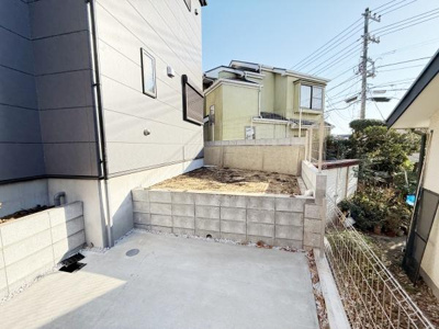 コンクリート舗装された駐車スペースが設けられています。お手入れのしやすい仕様で車の出し入れもスムーズに行えます。周囲にはブロック塀が施され隣地との境界も明瞭です。