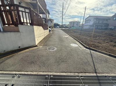 前面道路がしっかり舗装されており車の出入りもしやすい印象です。周辺は落ち着いた住宅街で安心感を感じられます。現地写真から空が広く開放感も魅力的です。周囲には歩道や住宅が整然と並んでいます。